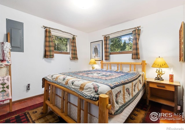 741 Hickory Dr, Lyons, CO 80540 - bedroom with wood finished floors, electric panel, baseboards, and multiple windows