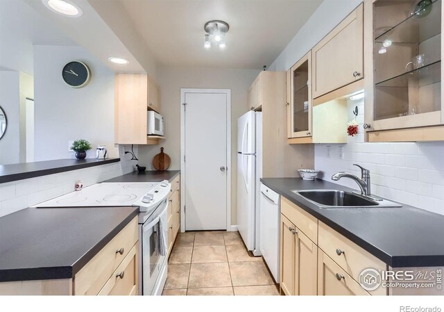 695 Manhattan Dr Unit 22, Boulder, CO 80303 - kitchen featuring decorative backsplash, dark countertops, a sink, and white appliances