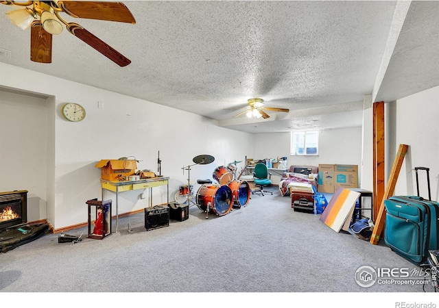 rec room featuring carpet floors, a textured ceiling, and ceiling fan