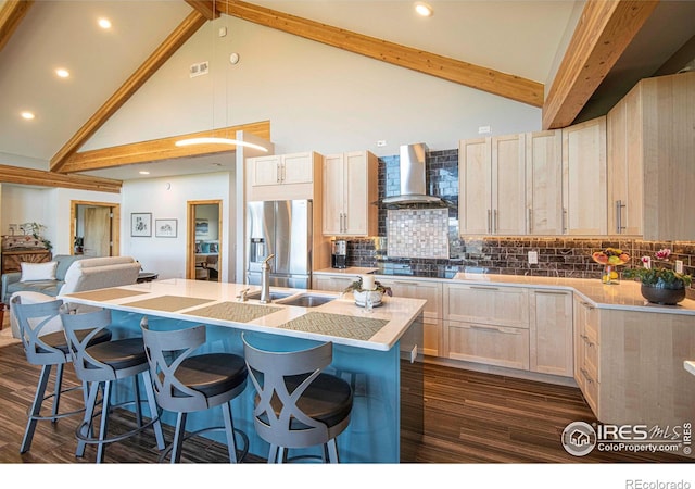 91 Eagle Rising Pl, Livermore, CO 80536 - kitchen with wall chimney exhaust hood, stainless steel refrigerator with ice dispenser, high vaulted ceiling, an island with sink, and a kitchen bar
