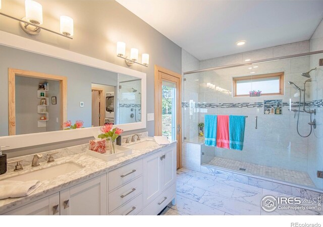 91 Eagle Rising Pl, Livermore, CO 80536 - bathroom with stacked washing machine and dryer, a shower stall, double vanity, marble look tiles, and recessed lighting
