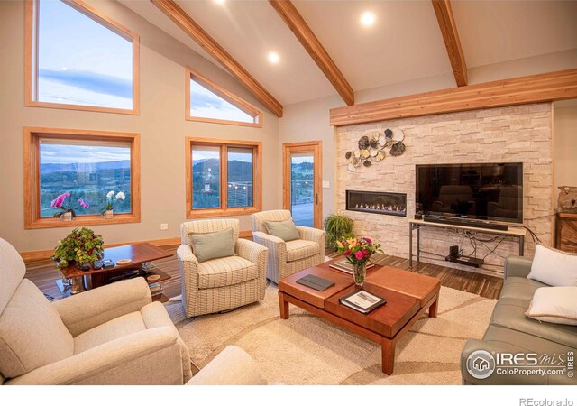 91 Eagle Rising Pl, Livermore, CO 80536 - living room featuring wood finished floors, beam ceiling, a fireplace, baseboards, and high vaulted ceiling