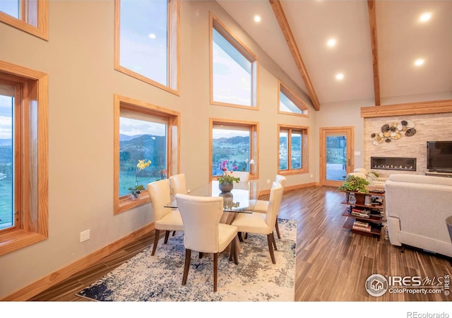 91 Eagle Rising Pl, Livermore, CO 80536 - dining room featuring high vaulted ceiling, beamed ceiling, baseboards, wood finished floors, and a fireplace