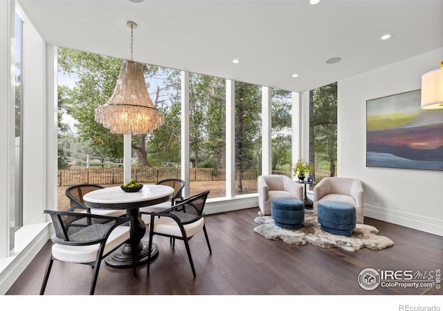 sunroom featuring plenty of natural light, expansive windows, a chandelier, wood finished floors, and recessed lighting