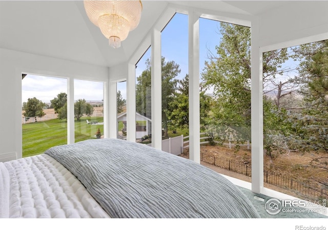 bedroom featuring vaulted ceiling, a chandelier, and multiple windows