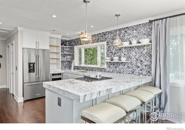 kitchen featuring appliances with stainless steel finishes, open shelves, crown molding, a peninsula, and light countertops