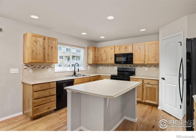 kitchen with light brown cabinetry, a sink, light wood-style floors, tasteful backsplash, and black appliances