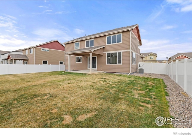 back of property with a lawn, a fenced backyard, and a patio area
