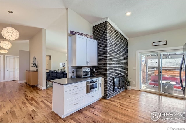 kitchen featuring white cabinetry, light wood finished floors, dark countertops, and oven