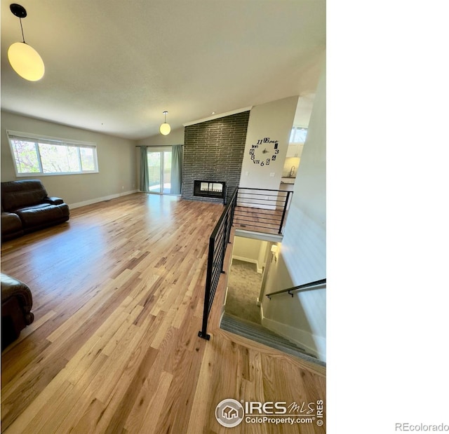 living area with baseboards, wood finished floors, and a fireplace