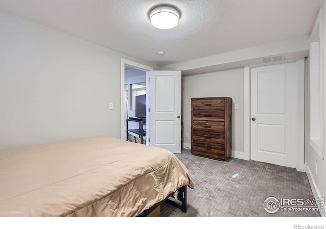 carpeted bedroom featuring visible vents and a textured ceiling