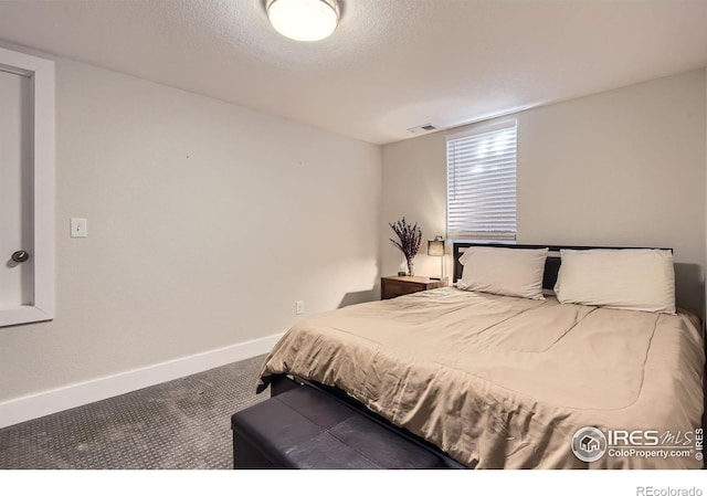 carpeted bedroom with baseboards, a textured ceiling, and visible vents