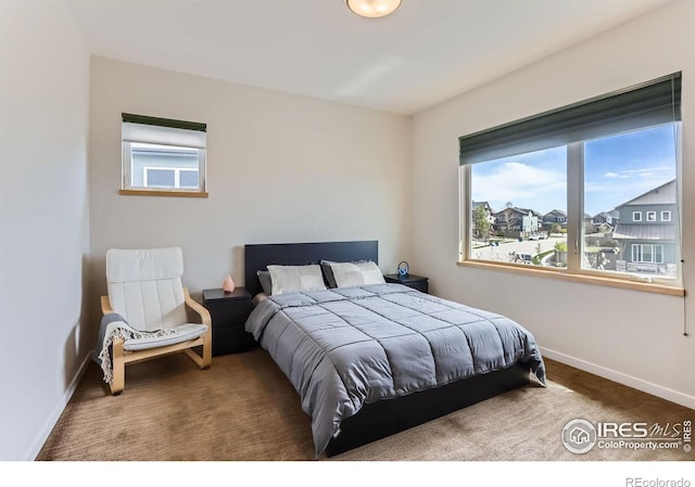 bedroom featuring baseboards, carpet flooring, and multiple windows