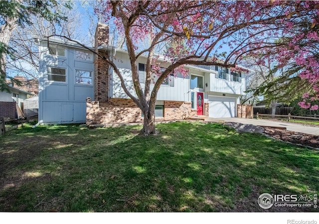 910 Sparta Dr, Lafayette, CO 80026 - raised ranch featuring fence, an attached garage, driveway, a front yard, and a chimney