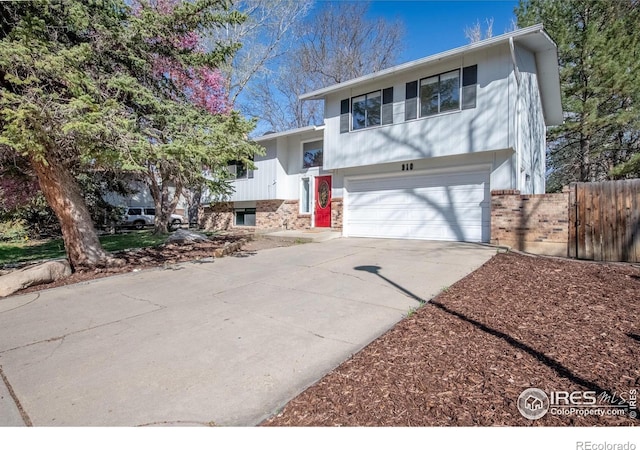 910 Sparta Dr, Lafayette, CO 80026 - view of front facade with driveway, brick siding, a garage, and fence