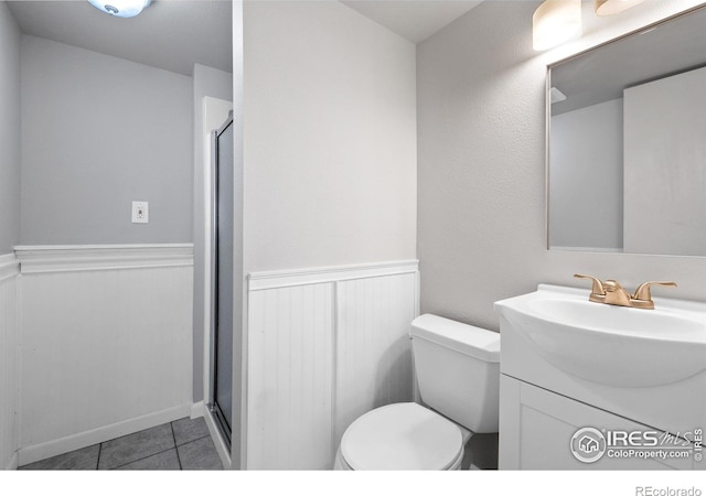 910 Sparta Dr, Lafayette, CO 80026 - bathroom featuring a stall shower, vanity, toilet, and a wainscoted wall