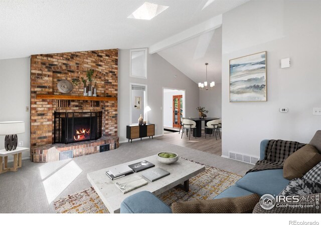 910 Sparta Dr, Lafayette, CO 80026 - living room featuring beam ceiling, visible vents, a brick fireplace, carpet floors, and a notable chandelier