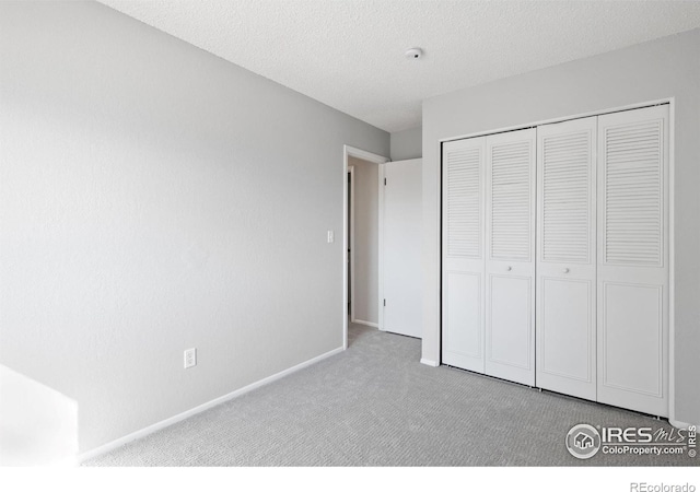910 Sparta Dr, Lafayette, CO 80026 - unfurnished bedroom with baseboards, a textured ceiling, a closet, and carpet
