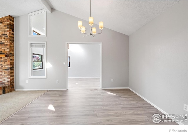 910 Sparta Dr, Lafayette, CO 80026 - unfurnished dining area with a textured ceiling, a notable chandelier, light wood-type flooring, and beam ceiling