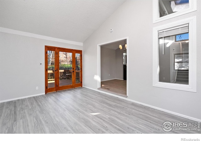 910 Sparta Dr, Lafayette, CO 80026 - empty room with lofted ceiling, a textured ceiling, baseboards, and wood finished floors