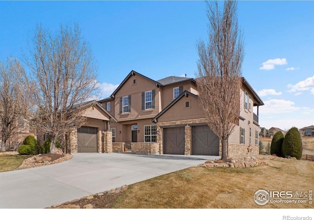 view of front of house with an attached garage, driveway, stone siding, and stucco siding