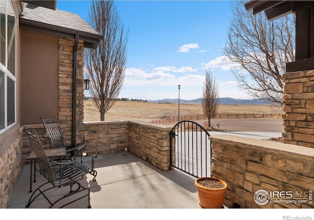 view of patio / terrace featuring a rural view and a mountain view