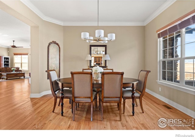 dining room with light wood-type flooring, visible vents, crown molding, and baseboards