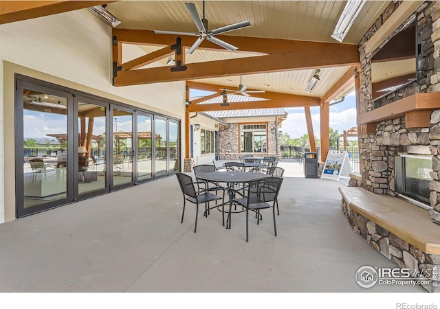 2719 Crystal Spgs, Longmont, CO 80503 - view of patio / terrace with an outdoor stone fireplace, a ceiling fan, and outdoor dining space