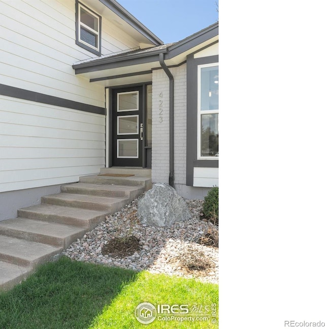 entrance to property featuring brick siding