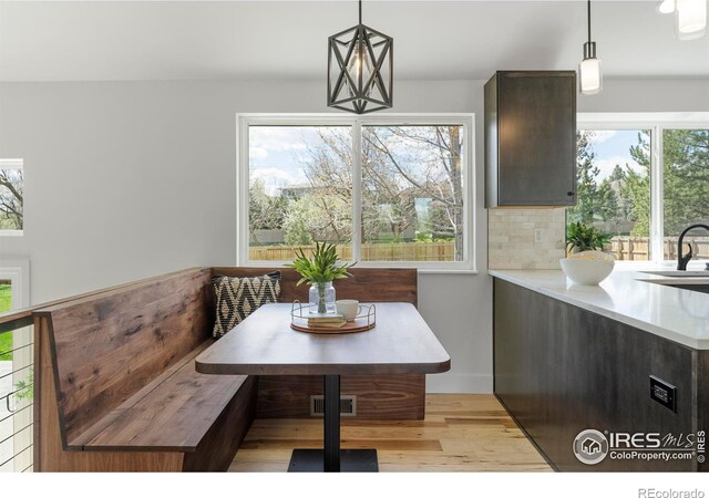 dining room featuring visible vents, light wood-style floors, breakfast area, and a healthy amount of sunlight