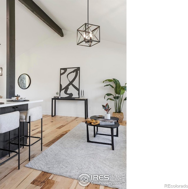 living room with wood finished floors, lofted ceiling with beams, and an inviting chandelier