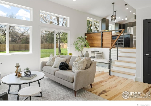 living room featuring recessed lighting, light wood finished floors, and stairs