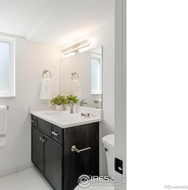 bathroom featuring tile patterned flooring, toilet, and vanity