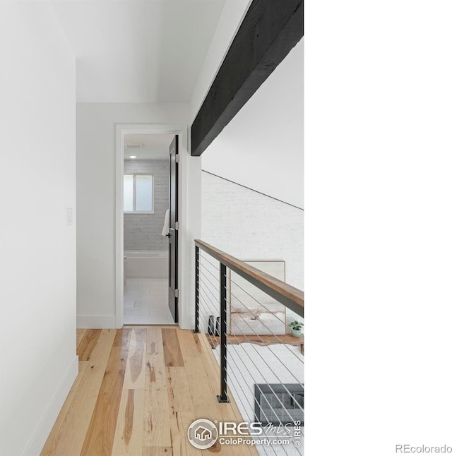 hallway featuring baseboards and wood finished floors