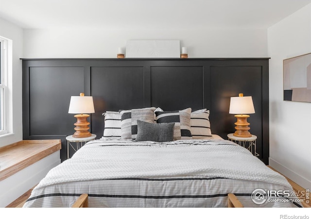 bedroom with baseboards and wood finished floors