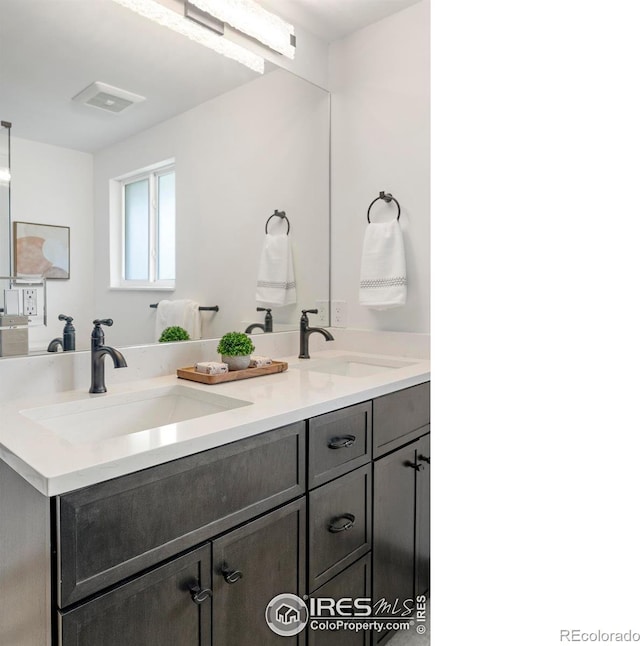 full bathroom with double vanity and a sink