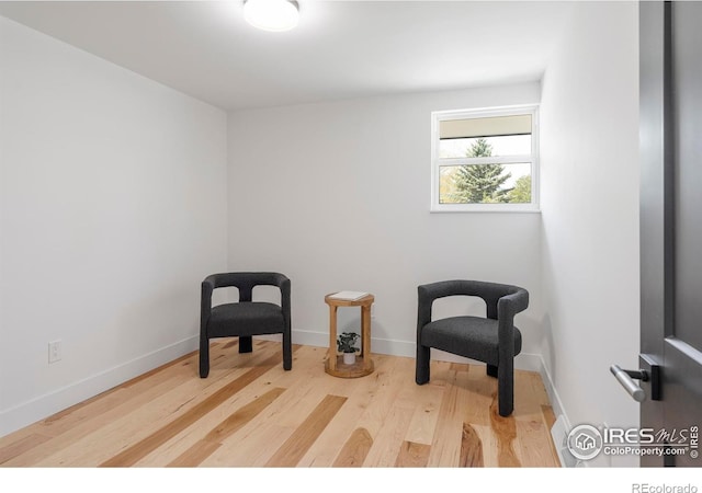 sitting room featuring baseboards and wood finished floors