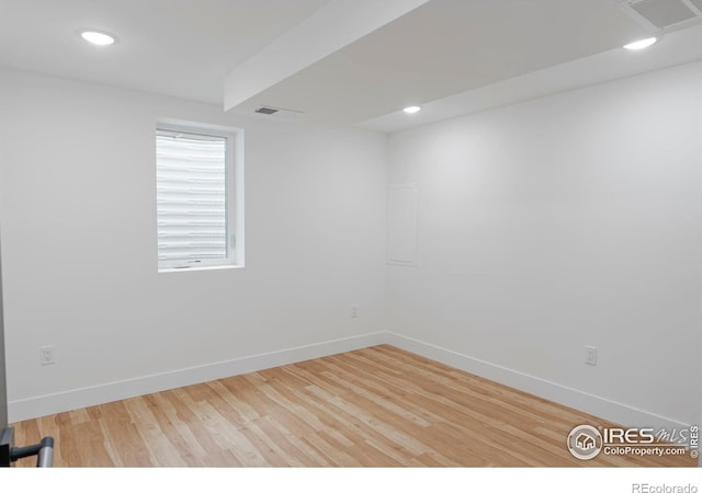 empty room with baseboards, wood finished floors, visible vents, and recessed lighting