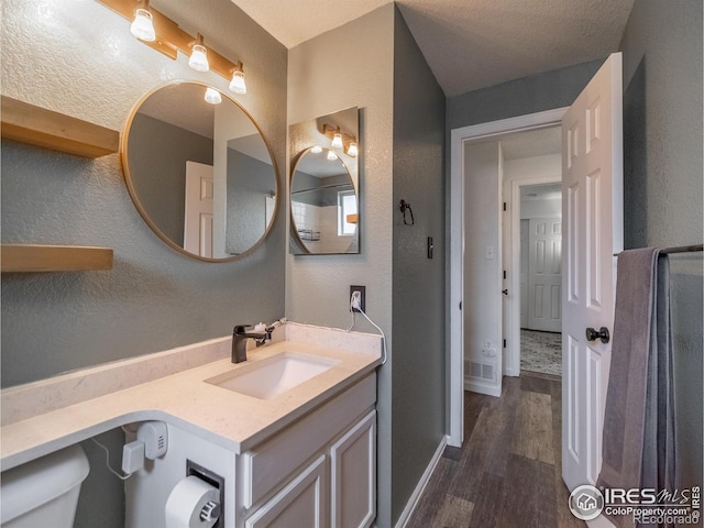 13146 Raritan Ct, Westminster, CO 80234 - bathroom featuring baseboards, a textured wall, wood finished floors, and vanity