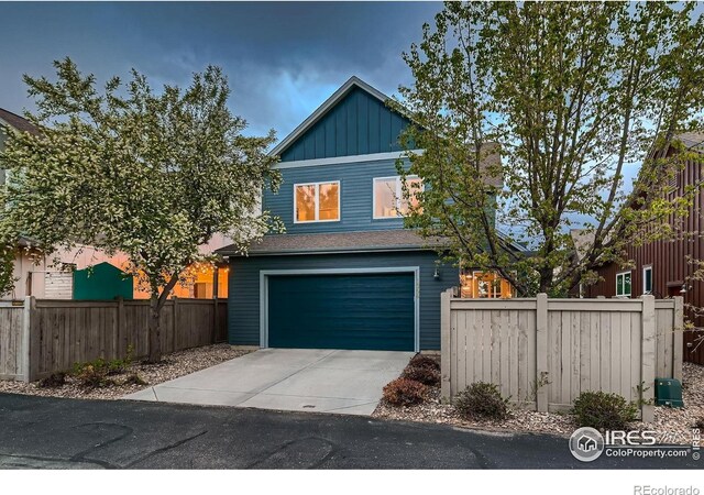 1356 Golden Eagle Way, Louisville, CO 80027 - view of front facade featuring board and batten siding, an attached garage, fence, and driveway