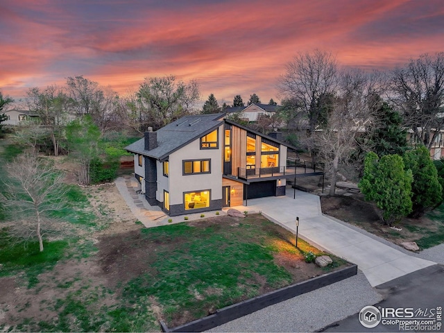 1048 Westview Dr, Boulder, CO 80303 - view of front of house featuring a garage, a chimney, concrete driveway, and stucco siding
