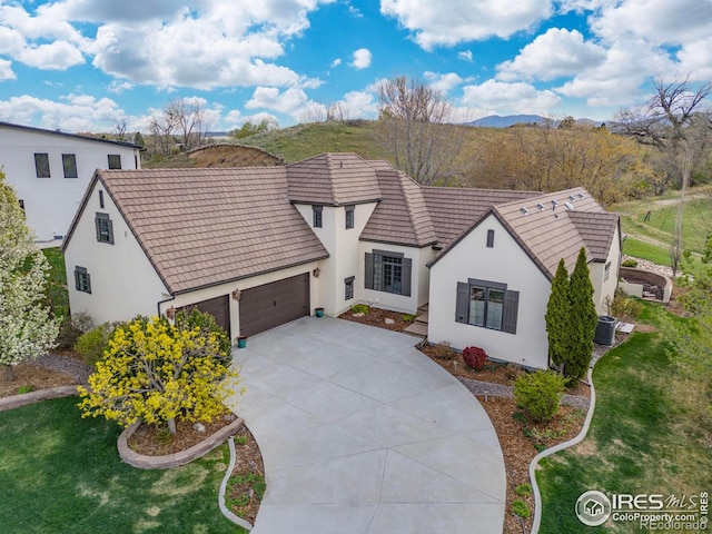 895 Owl Grove Pl, Loveland, CO 80537 - view of front of home featuring an attached garage, a tile roof, driveway, and stucco siding