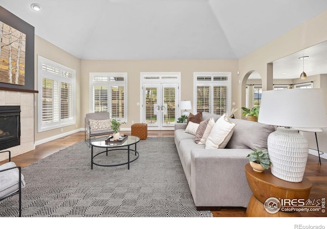 895 Owl Grove Pl, Loveland, CO 80537 - living area featuring a tile fireplace, lofted ceiling, french doors, and wood finished floors