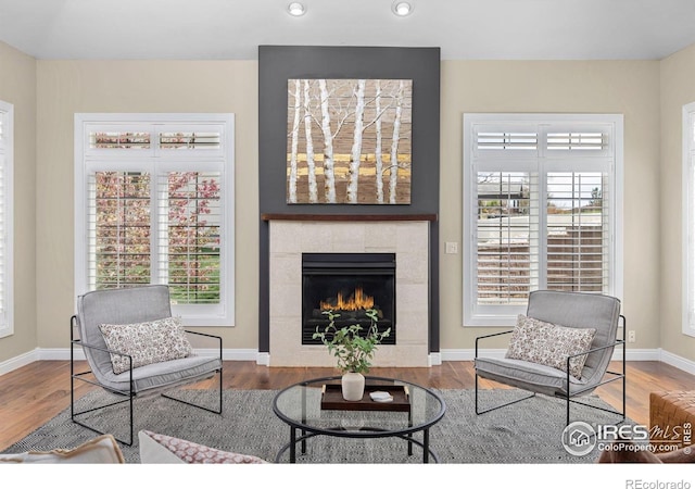 895 Owl Grove Pl, Loveland, CO 80537 - living room with a tiled fireplace, wood finished floors, a wealth of natural light, and recessed lighting