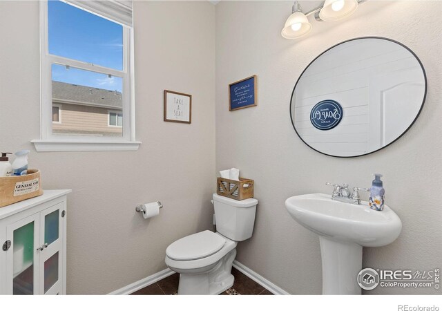4737 Sandy Ridge Ave, Firestone, CO 80504 - bathroom featuring toilet, baseboards, a sink, and tile patterned floors