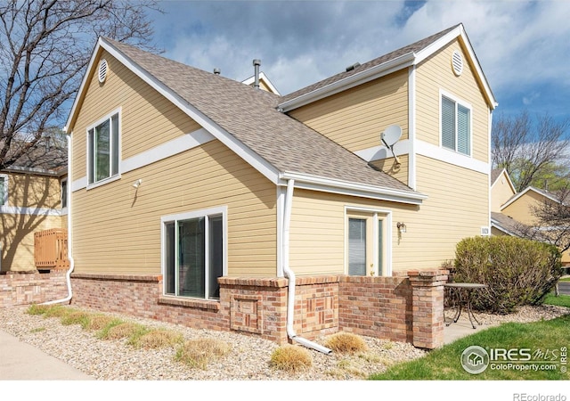 1020 Rolland Moore Dr Unit 2D, Fort Collins, CO 80526 - view of home's exterior with brick siding and roof with shingles