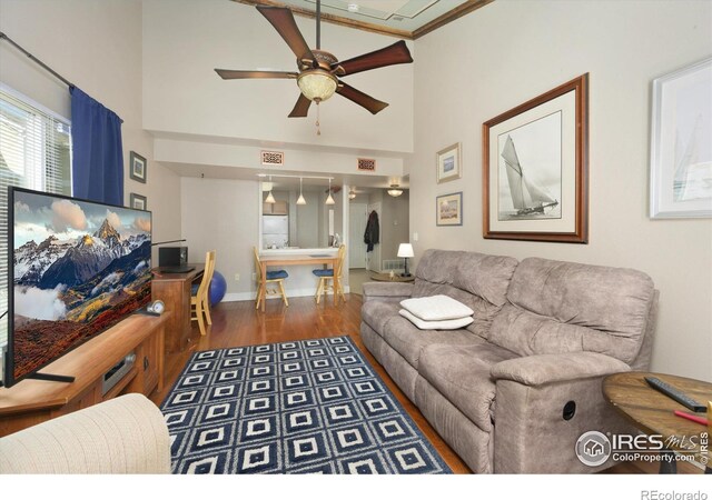1020 Rolland Moore Dr Unit 2D, Fort Collins, CO 80526 - living room featuring a high ceiling, a ceiling fan, wood finished floors, and baseboards