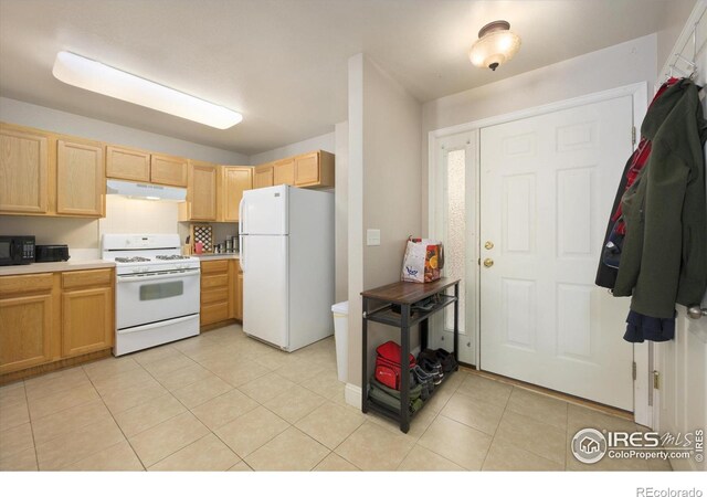 1020 Rolland Moore Dr Unit 2D, Fort Collins, CO 80526 - kitchen featuring under cabinet range hood, light countertops, light brown cabinets, white appliances, and light tile patterned flooring