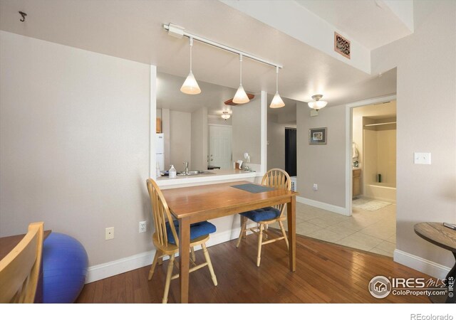 1020 Rolland Moore Dr Unit 2D, Fort Collins, CO 80526 - dining area with baseboards, wood finished floors, visible vents, and track lighting