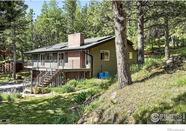74 Sky Trail Rd, Boulder, CO 80302 - view of front of house with a shed, stairway, a chimney, a deck, and brick siding
